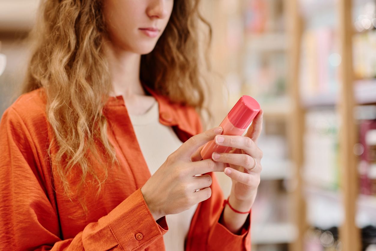 a woman looks at a cosmetic that perfectly adhere's to MoCRA's cosmetic label requirements.