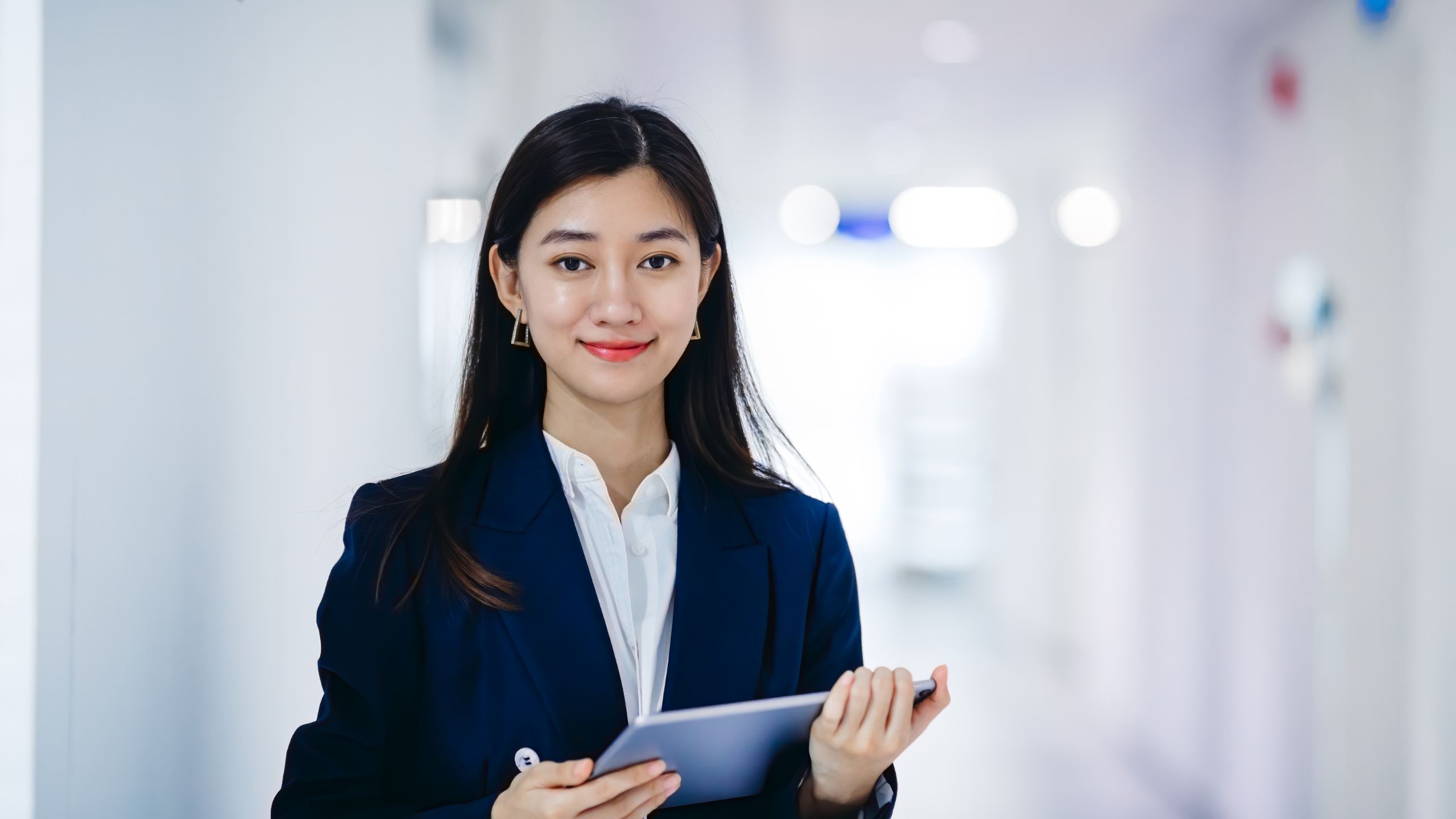 A young woman acting as a cross-functional PCQI stands smiling in an office hallway.