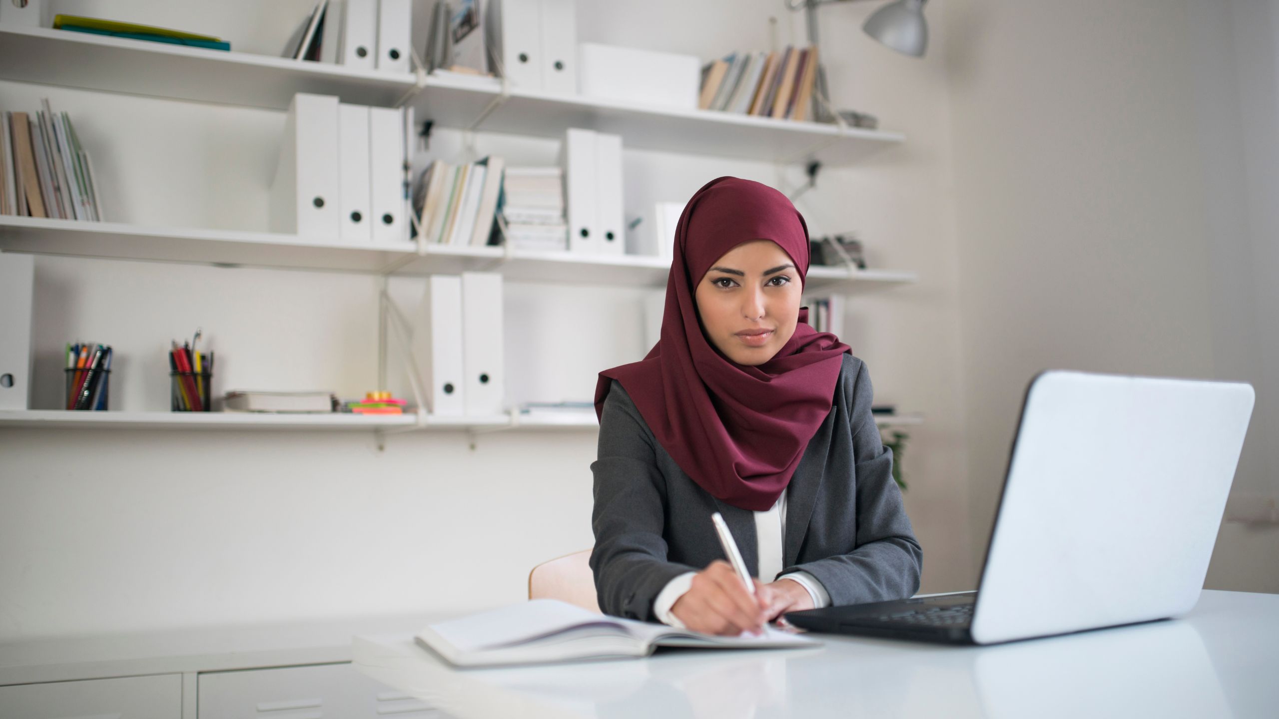 A woman sits at her desk as she reviews the SQF Certification Process.