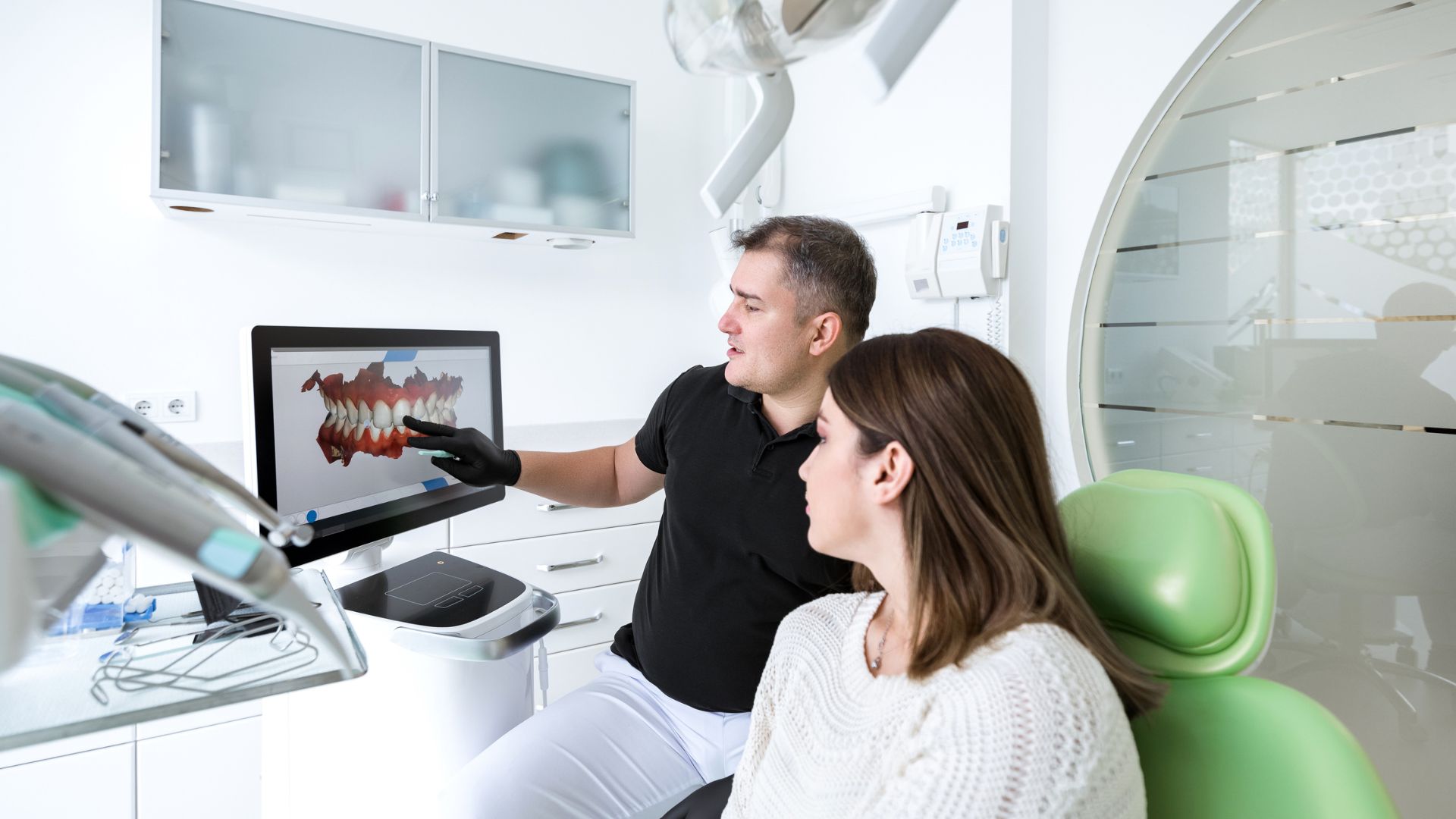 A dentist shows his patient her teeth on a CAD/CAM Dental System