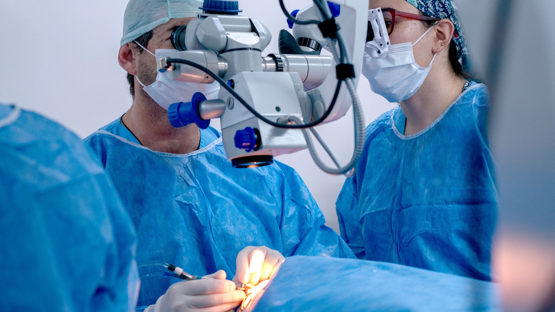 A doctor uses an Ophthalmic Surgical Device to assist in the operation.